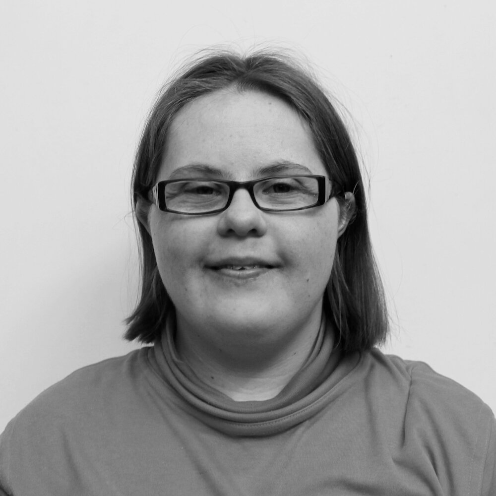 Black and white portrait of young woman with Down syndrome wearing glasses