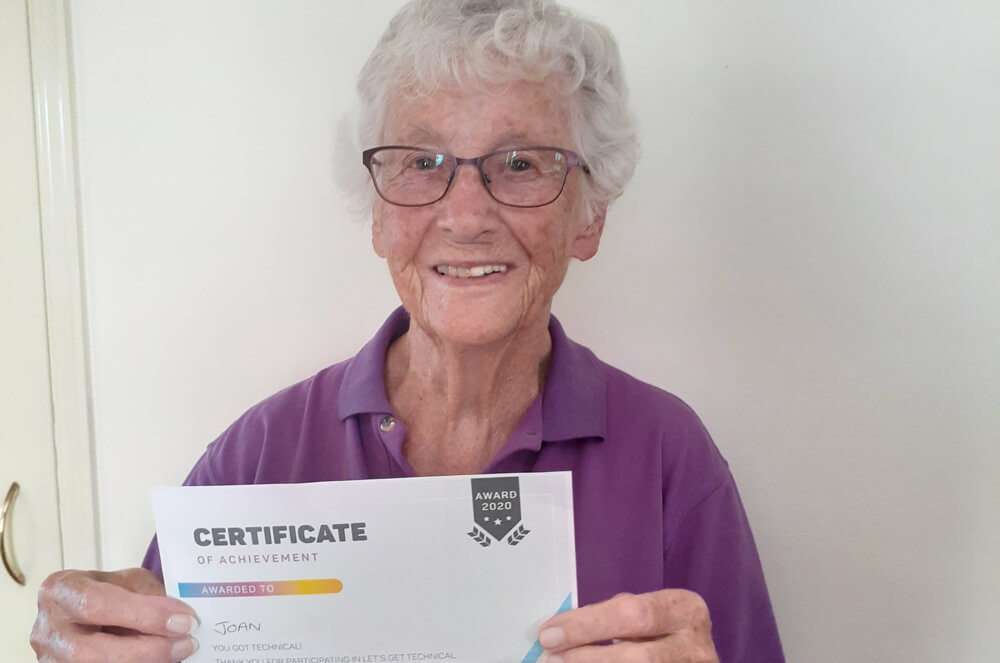 Photo of Joan and her certificate of achievement