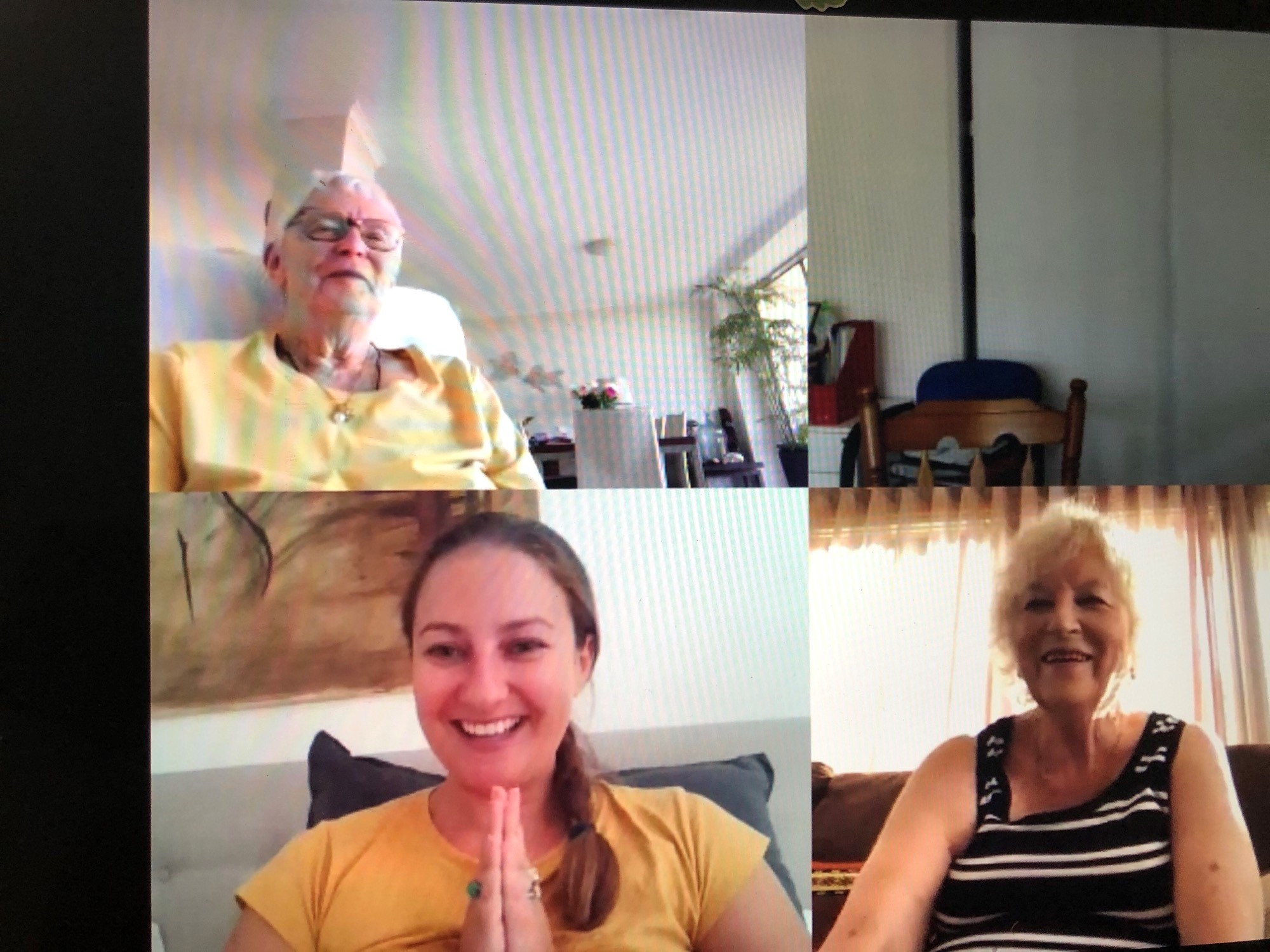 Three people on screen on a virtual call - one young woman and two seniors