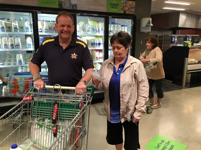 Man in his fifties and woman standing next to a shopping trolley