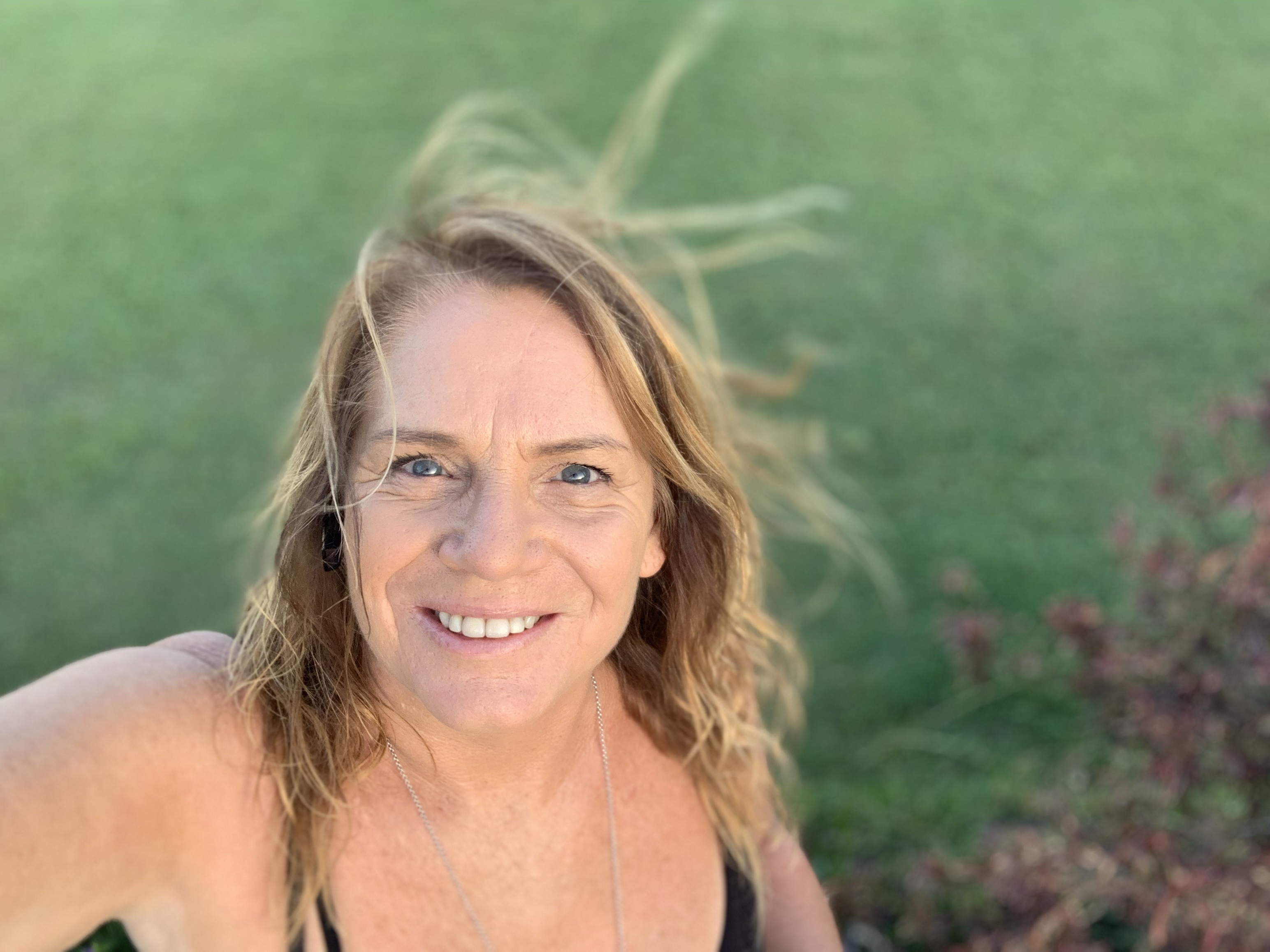 Woman grinning into camera in grass
