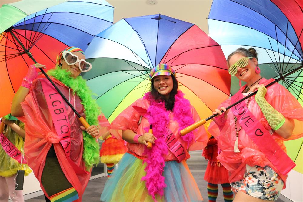 Three girls dressed up colourfully for Mardi Gras