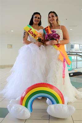 Two women dressed up in wedding dresses for Mardi Gras
