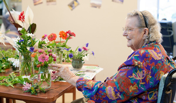 Senior arranging flowers in a vase