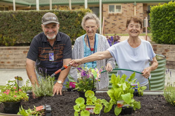 Seniors planting flowers in garden