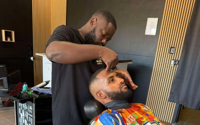 Barber Sengo Mussa cutting hair