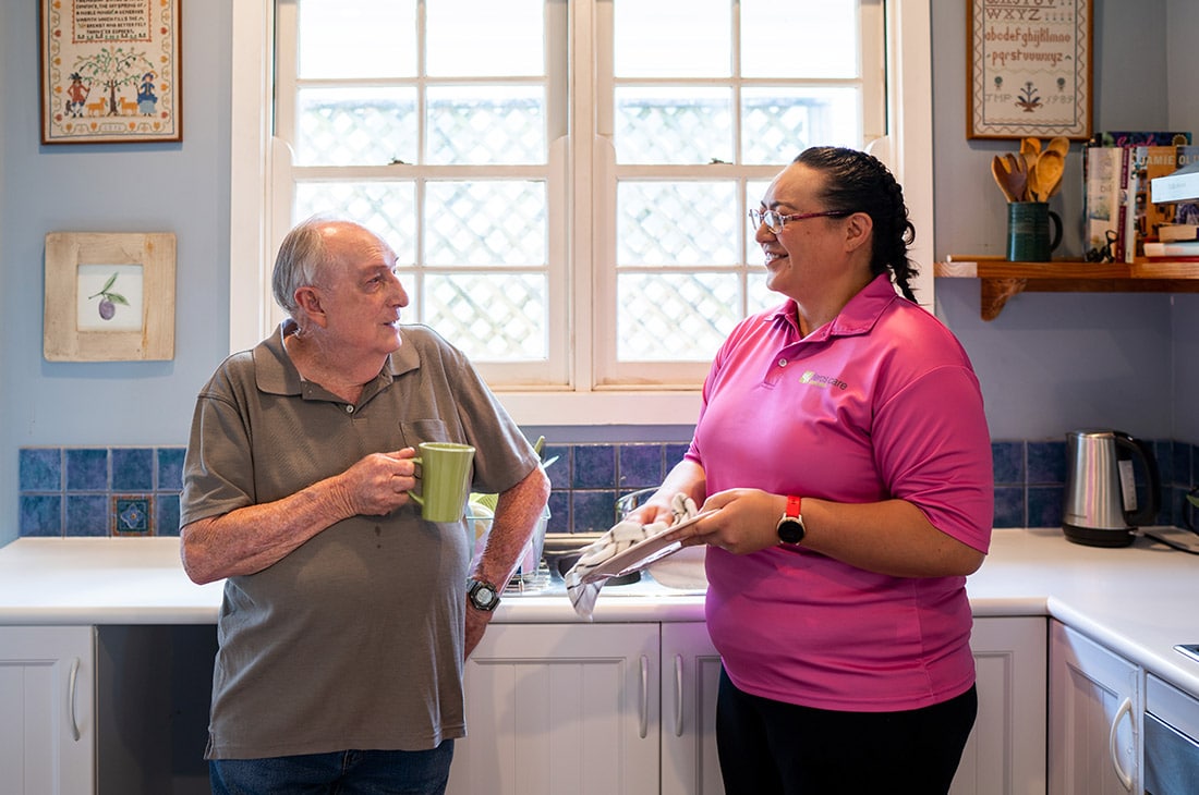Photo of Community Support Worker drying dishes with client