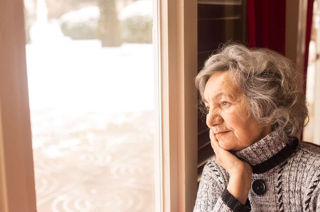 Photo of senior woman looking out window