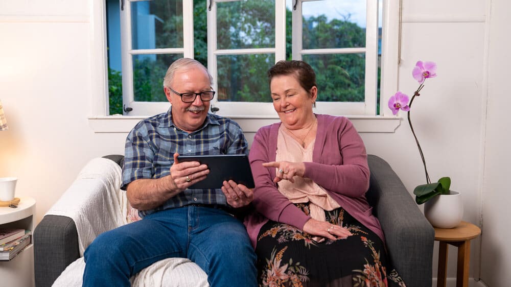 Photo of older man and woman using tablet
