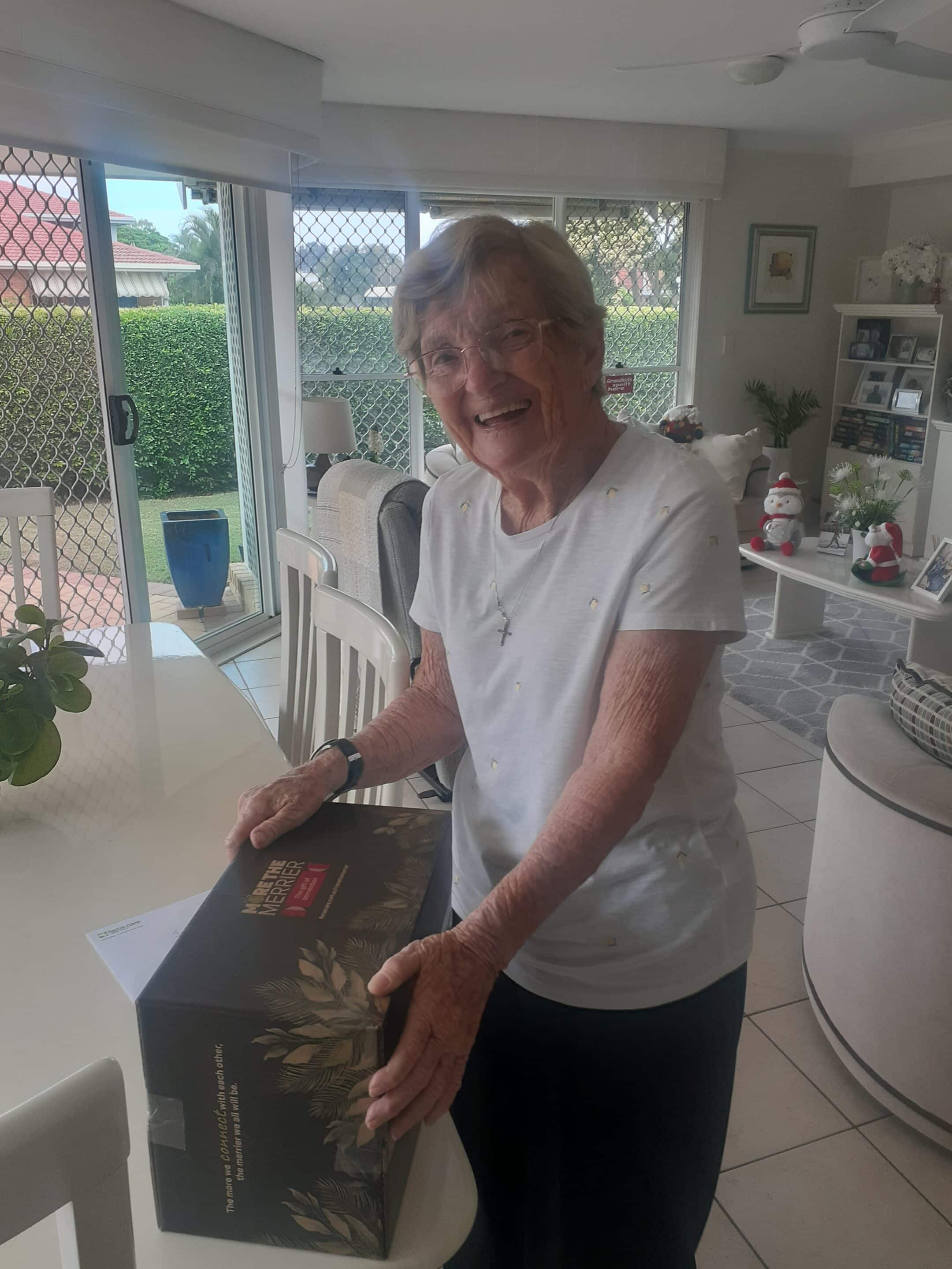 Old lady in kitchen receiving a Christmas hamper from charity organisation on the Gold Coast.