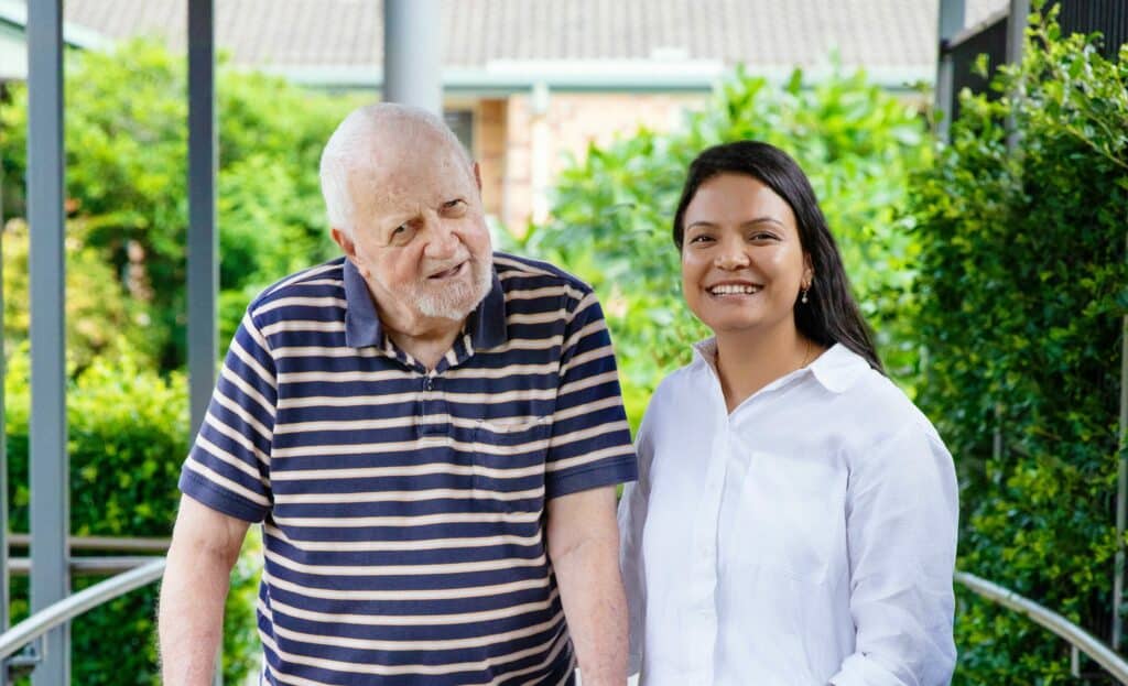 Deepa, Clinical Manager at Wommin Bay Village, smiling with resident Bernie (also smiling!)