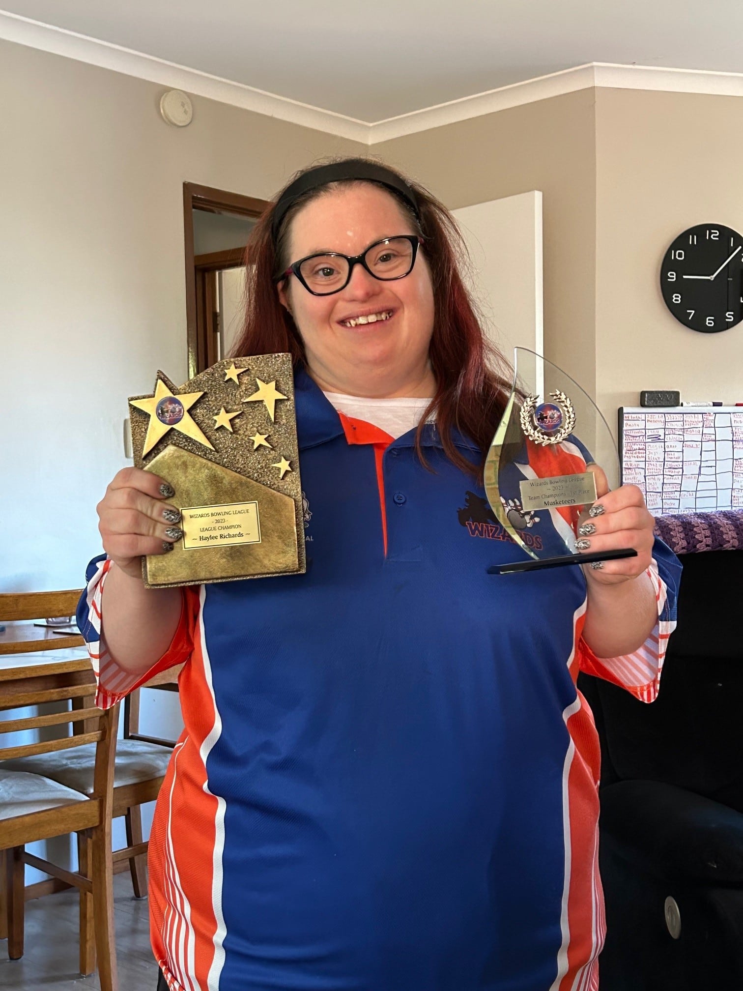 Woman with Down syndrome holding up medal she won for ten-pin bowling