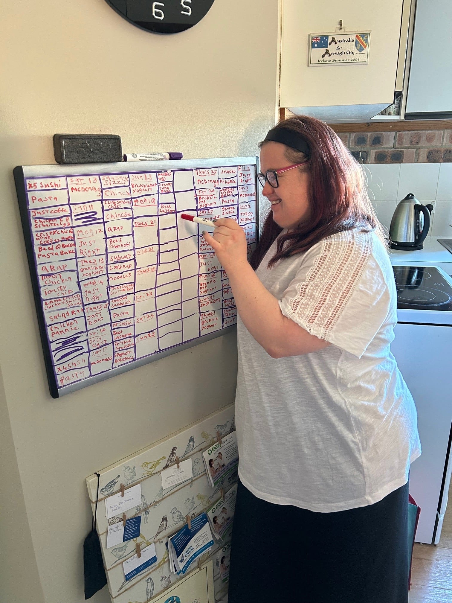 Woman with Down syndrome writing chores on a whiteboard
