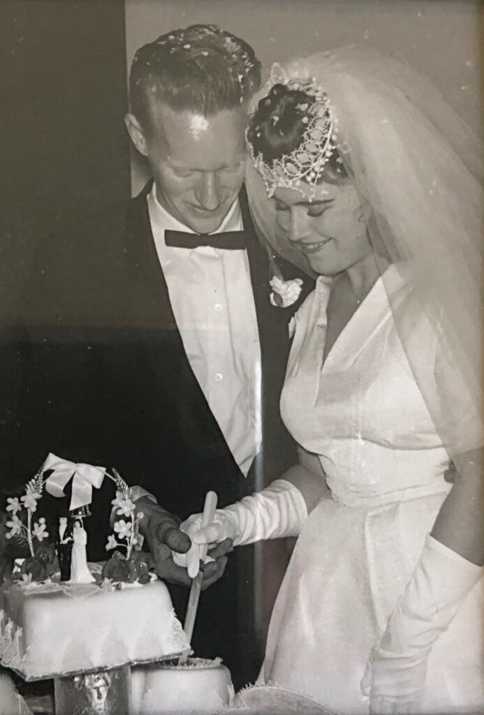 Feros Care HCP clients Dianne and Keith on their wedding day cutting the wedding cake