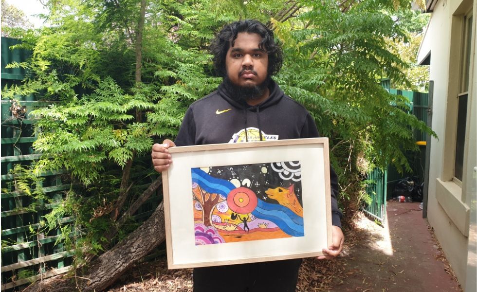 First Nations man holding colourful painting