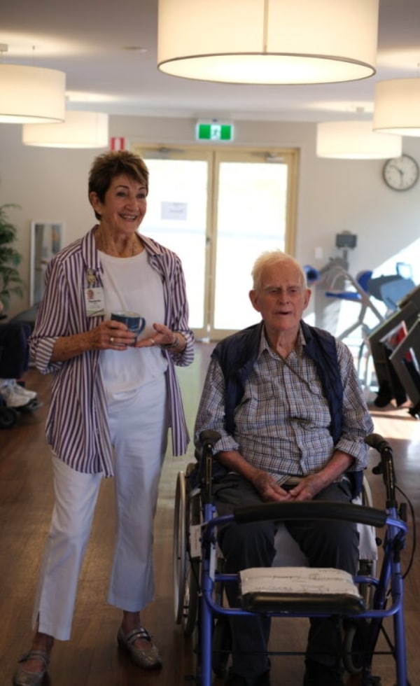 woman with old man in wheelchair at Feros Care Wommin Bay village aged care