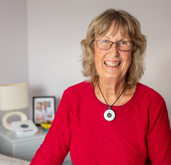 Lady wearing personal alarm smiling Lady wearing personal alarm smiling