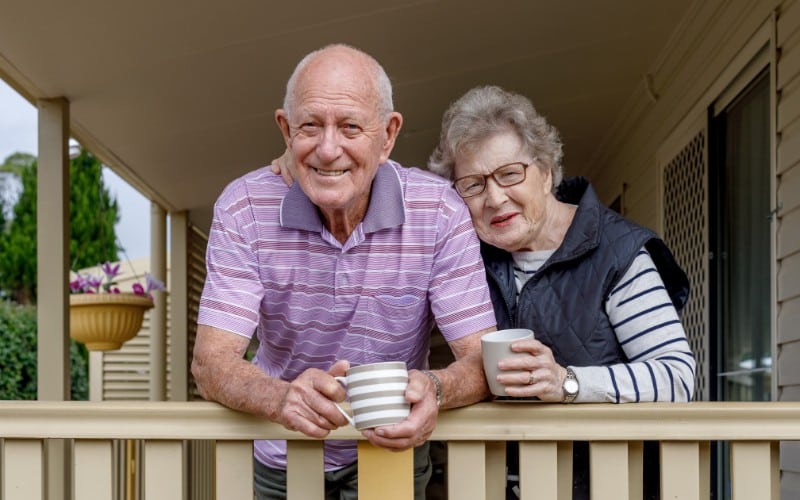 Seniors at home Photo of older couple leaning on porch railing